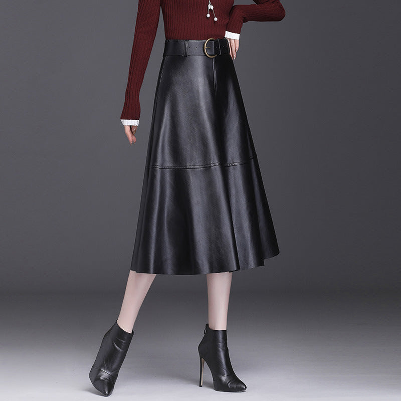 Gonna lunga in pelle nera, abbinata a stivaletti neri con tacco alto e maglione rosso. Moda autunnale elegante e chic.