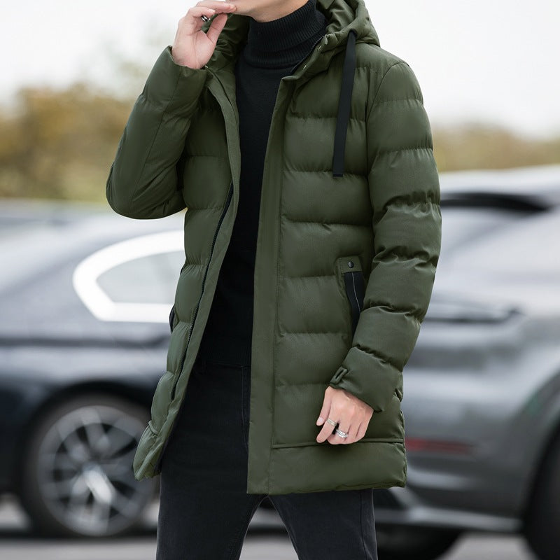Giacca invernale verde uomo, imbottita e con cappuccio, indossata all'aperto. Moda maschile, abbigliamento caldo, stile casual.