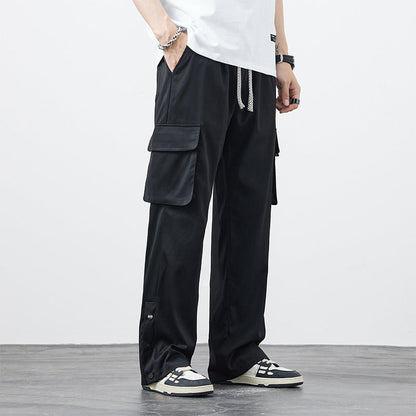 Pantaloni cargo neri da uomo con tasche laterali, indossati con sneakers bianche e nere. Stile casual, moda urbana, abbigliamento maschile moderno.