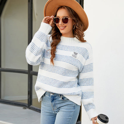 Donna sorridente con cappello marrone, occhiali da sole e maglione a righe bianche e blu, tiene una tazza da caffè. Moda autunnale casual.
