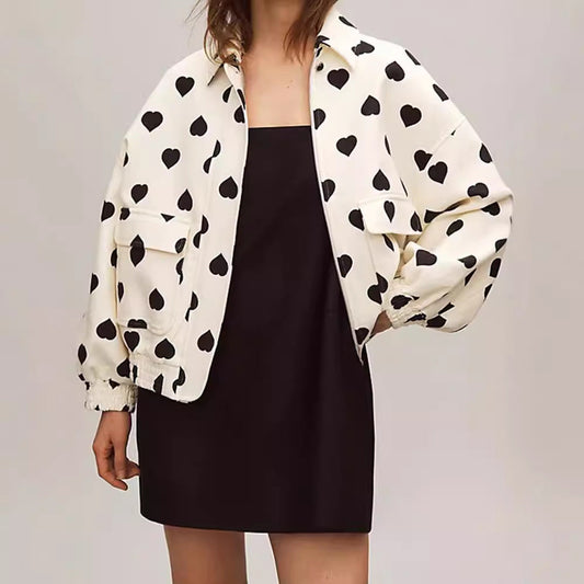 Giacca bianca con cuori neri, abbinata a un abito nero. Moda femminile elegante, stile casual chic, tendenze abbigliamento 2023.