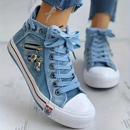 Scarpe da ginnastica alte in denim blu con cerniera e decorazione a teschio, suola bianca, lacci azzurri, moda casual, stile urbano.