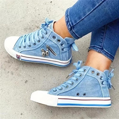 Scarpe da ginnastica alte in denim blu con lacci, dettagli in metallo e suola bianca. Moda casual, calzature trendy per giovani.