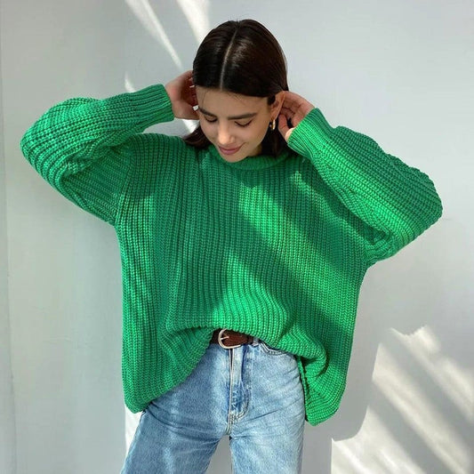 Donna con maglione verde oversize e jeans chiari, posa in un ambiente luminoso. Moda casual, stile autunnale, abbigliamento confortevole.
