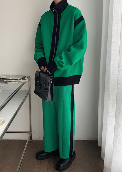 Tuta sportiva verde con dettagli neri, giacca con zip e pantaloni abbinati, borsa a tracolla nera, scarpe nere, stile casual moderno.