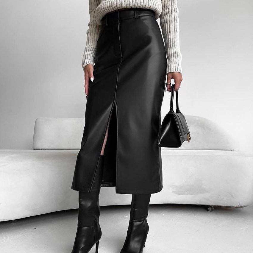 Donna con gonna lunga in pelle nera con spacco, stivali alti e maglione bianco. Moda autunnale elegante, outfit chic e moderno.