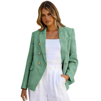 Donna con blazer verde elegante, bottoni dorati, indossa top bianco e pantaloni bianchi. Moda femminile, abbigliamento chic, stile estivo.