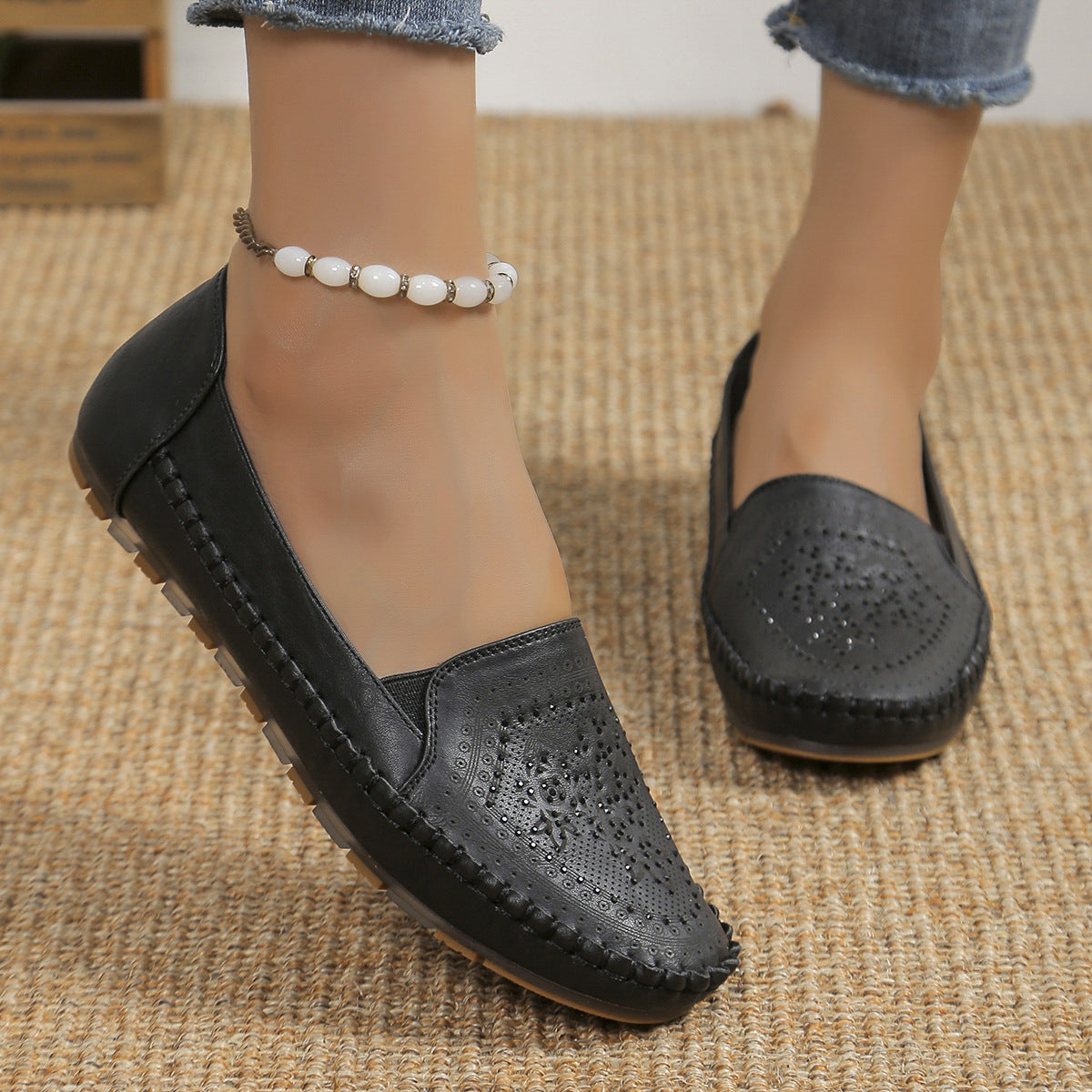 Scarpe mocassini donna in pelle nera, design traforato, suola antiscivolo, indossate con jeans. Eleganti e comode per look casual.
