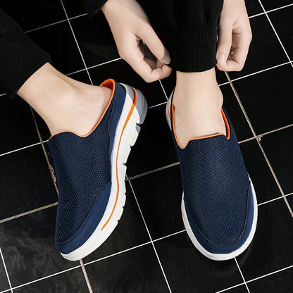 Scarpe slip-on blu scuro con suola bianca e dettagli arancioni, indossate su piastrelle nere. Calzature casual estive, comode e traspiranti.
