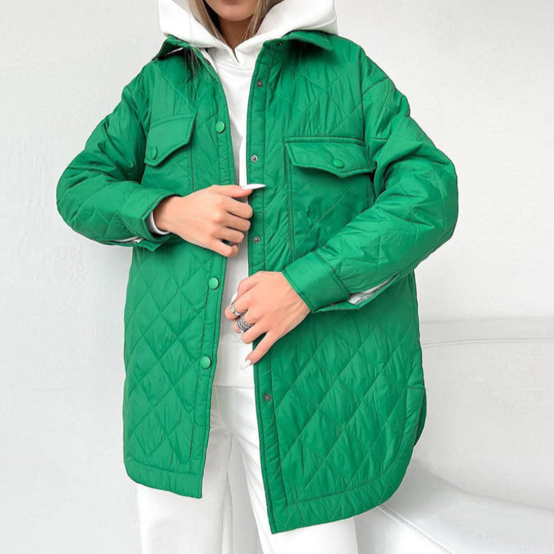 Giacca trapuntata verde brillante indossata da una donna su abbigliamento bianco. Moda autunnale, stile casual, tendenza abbigliamento femminile.