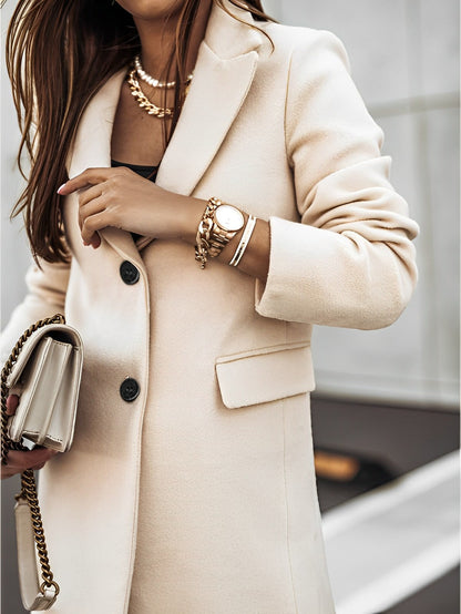 Donna con cappotto beige elegante, orologio e bracciali dorati, borsa a catena. Moda autunnale, stile chic, accessori di lusso.