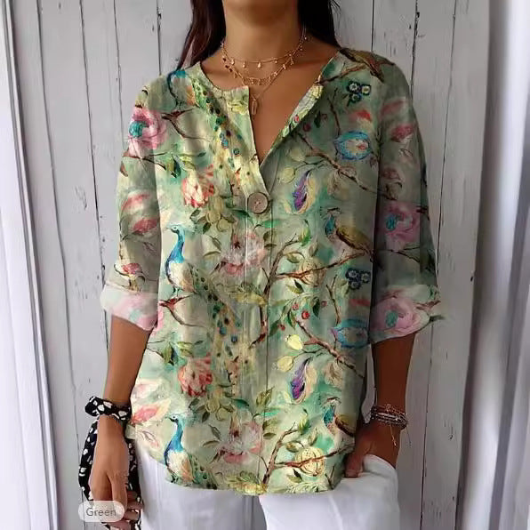 Camicia donna floreale con pavoni, maniche lunghe, sfondo verde chiaro, bottoni frontali, stile casual elegante, perfetta per primavera estate.