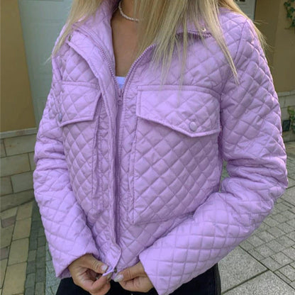 Giacca trapuntata viola chiaro indossata da una donna, con tasche frontali e cerniera, su sfondo esterno. Moda autunnale, abbigliamento casual.