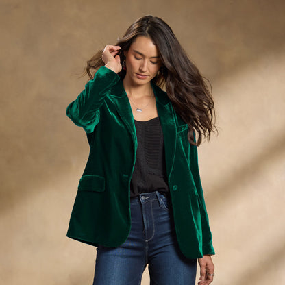 Donna con giacca di velluto verde, camicia nera e jeans. Moda autunnale elegante, abbigliamento casual chic, tendenze moda 2023.