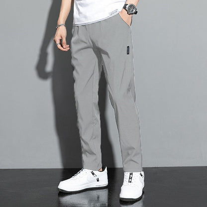 Pantaloni grigi da uomo, stile casual, abbinati a scarpe da ginnastica bianche. Moda maschile moderna, abbigliamento comodo ed elegante.