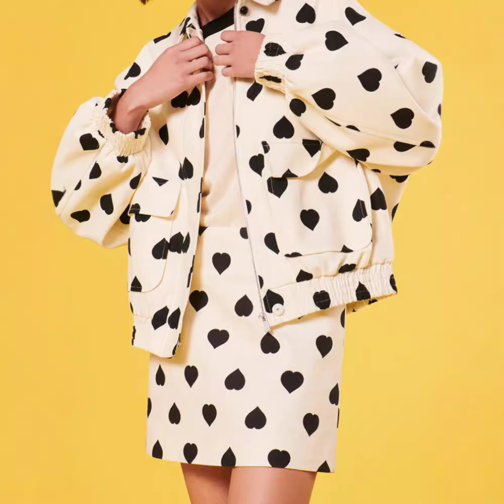 Giacca e gonna beige con stampa a cuori neri su sfondo giallo. Moda femminile, abbigliamento trendy, stile casual chic, outfit autunnale.