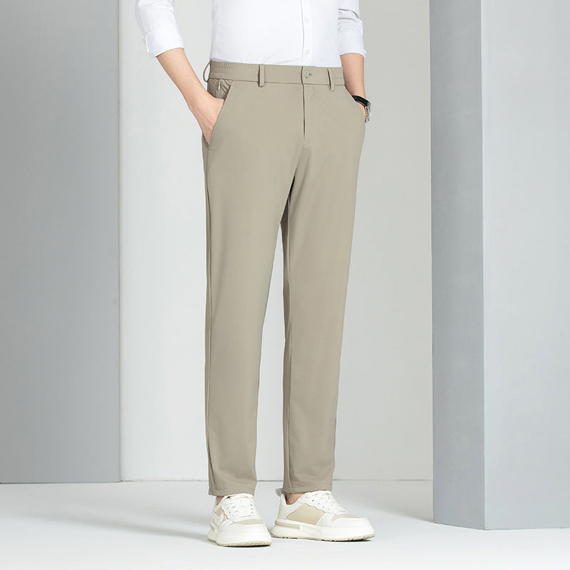 Pantaloni chino beige da uomo, eleganti e moderni, abbinati a camicia bianca e sneakers bianche. Moda maschile casual e raffinata.