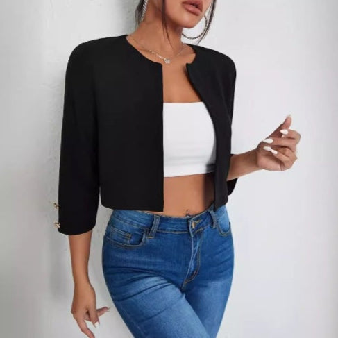 Donna con giacca nera elegante, top bianco e jeans aderenti. Moda casual chic, abbigliamento femminile trendy, outfit moderno per ogni occasione.