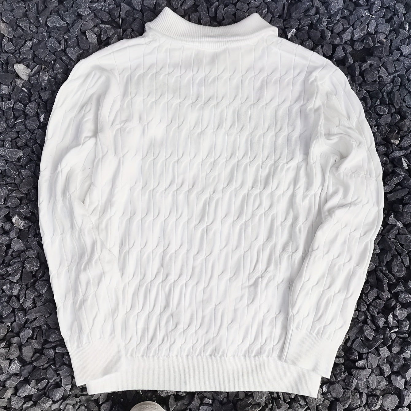 Maglione bianco a maglia intrecciata su sfondo di pietre grigie, design elegante e moderno, moda autunno inverno, abbigliamento casual uomo.