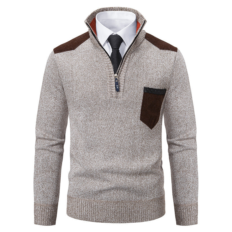 Maglione grigio da uomo con zip, dettagli marroni su spalle e taschino, indossato sopra camicia bianca e cravatta nera. Elegante e casual.