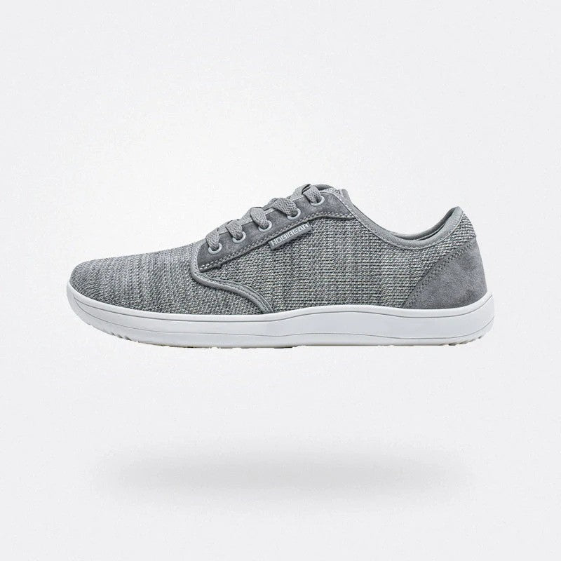 Scarpa da ginnastica grigia in tessuto, suola bianca, design moderno e minimalista, ideale per sport e tempo libero. Comfort e stile casual.