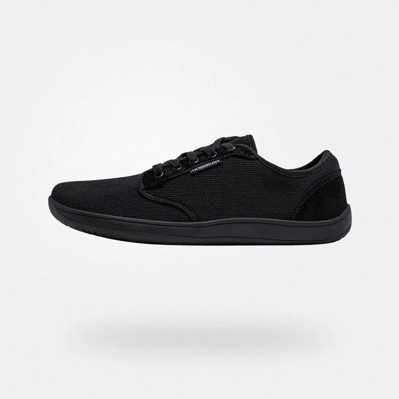 Scarpa sportiva nera minimalista su sfondo bianco, design leggero e moderno, perfetta per attività sportive e casual. Scarpe da ginnastica eleganti.