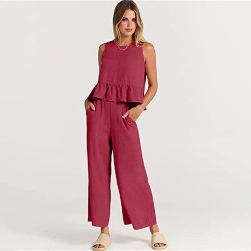 Donna in tuta rossa elegante, senza maniche, con pantaloni larghi e sandali beige. Moda femminile, abbigliamento estivo, stile casual chic.