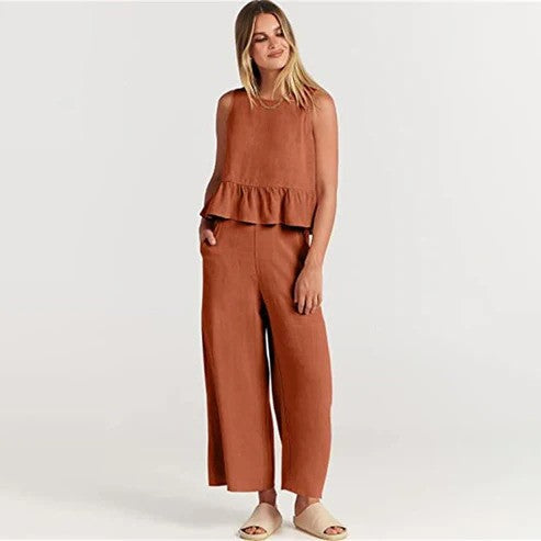 Donna in tuta marrone con volant, posa su sfondo bianco. Moda femminile, abbigliamento casual elegante, stile estivo.