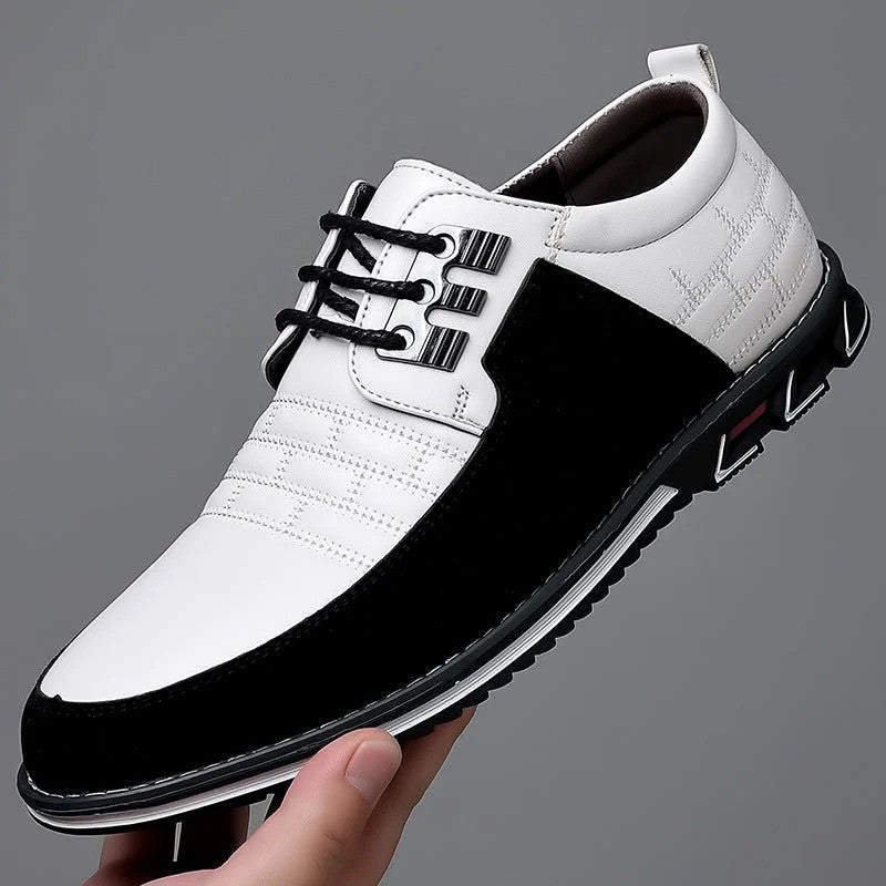 Scarpa elegante da uomo in pelle bianca e nera, con suola antiscivolo e lacci neri. Design moderno, ideale per abbigliamento formale e casual.