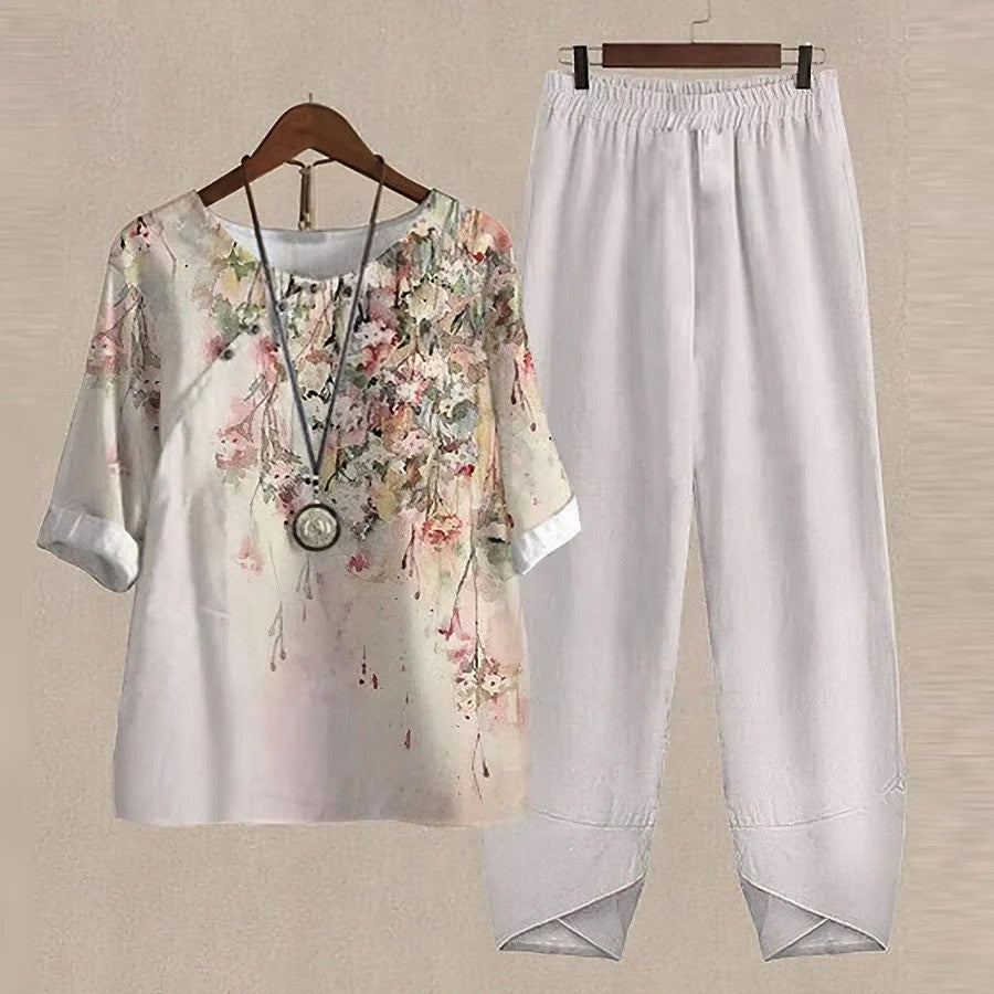 Completo donna estivo, maglia floreale con maniche corte e pantaloni bianchi larghi. Moda casual, abbigliamento leggero e comodo.