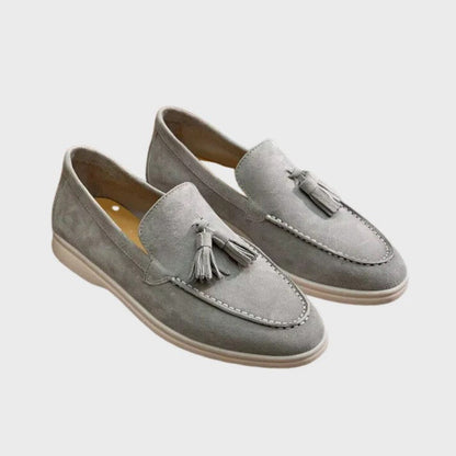 Mocassini uomo in pelle scamosciata grigia con nappine, suola beige. Scarpe eleganti e casual, ideali per moda maschile e abbigliamento estivo.