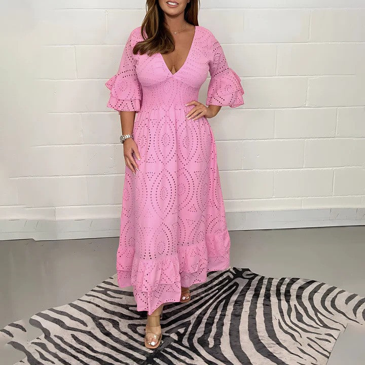 Donna in abito rosa con motivo traforato, maniche a volant, su tappeto zebrato. Moda femminile elegante, abbigliamento estivo, tendenze 2023.