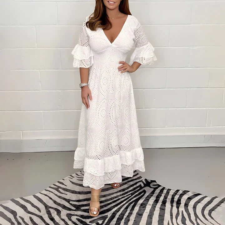 Donna in abito bianco lungo con maniche a volant, su tappeto zebrato. Moda elegante, abbigliamento estivo, stile femminile, tendenza 2023.