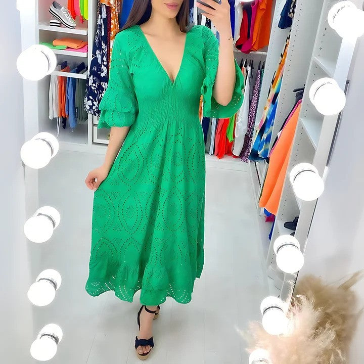 Donna in abito verde elegante con scollo a V, in cabina armadio illuminata. Moda femminile, abbigliamento estivo, tendenze 2023.