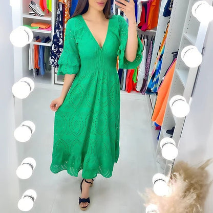 Donna in abito verde elegante con scollo a V, in cabina armadio illuminata. Moda femminile, abbigliamento estivo, tendenze 2023.
