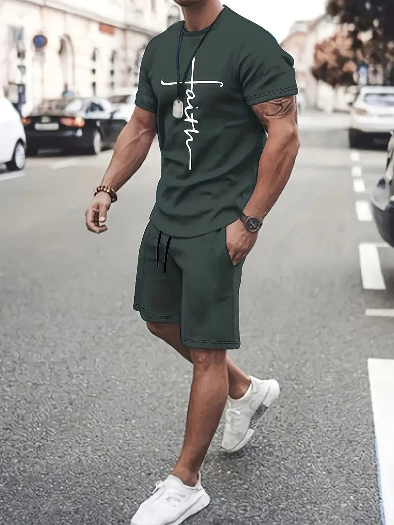 Uomo muscoloso in abbigliamento sportivo verde scuro con scritta "faith", cammina in città. Indossa scarpe bianche e orologio. Sfondo urbano trafficato.