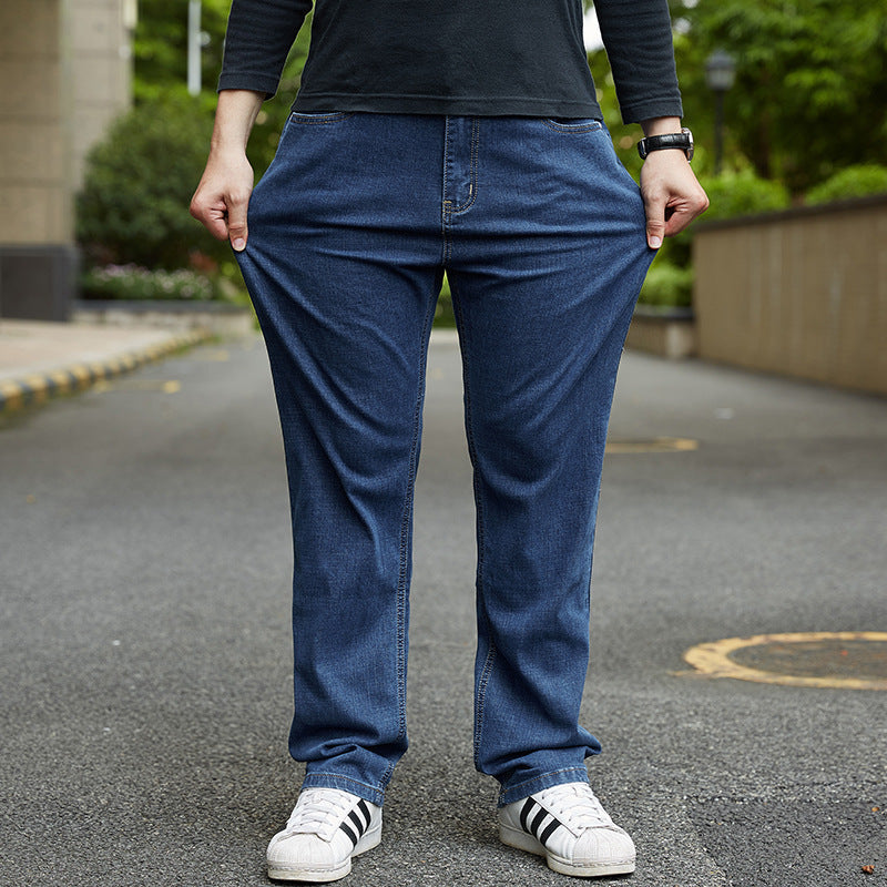 Persona che indossa jeans larghi blu e scarpe da ginnastica bianche su strada asfaltata, moda casual, abbigliamento comodo, tendenza oversize.