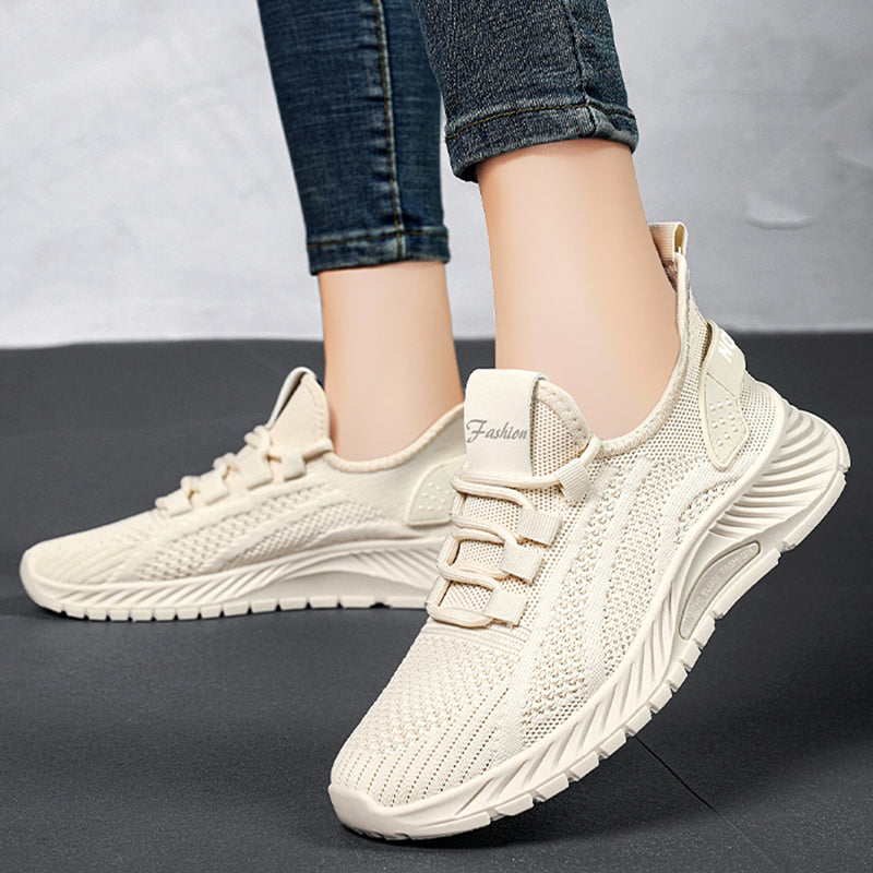 Scarpe da ginnastica beige su sfondo grigio, design moderno e traspirante, perfette per attività sportive e casual. Sneakers moda donna.