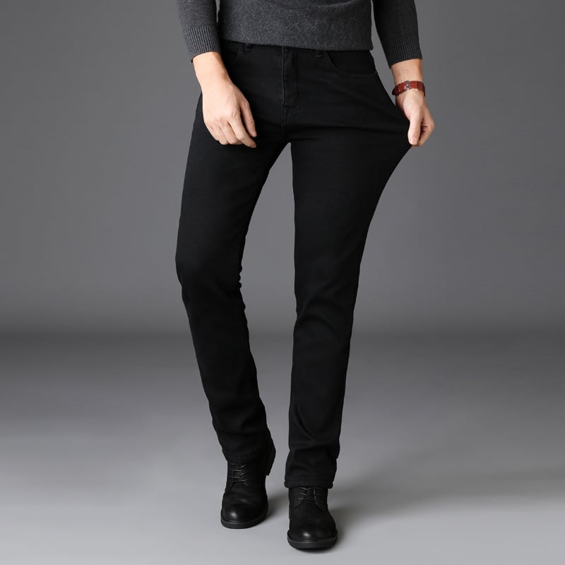 Jeans neri elasticizzati da donna, vestibilità slim, abbinati a maglione grigio e stivaletti neri, moda casual autunno inverno.