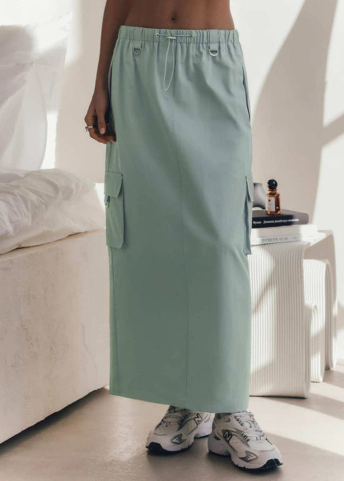 Gonna lunga verde menta con tasche cargo, indossata con sneakers bianche. Stile casual e moderno, perfetto per look estivi e urbani.