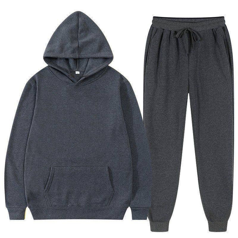 Tuta sportiva grigia in cotone, composta da felpa con cappuccio e pantaloni con coulisse. Abbigliamento casual e comodo per uomo e donna.