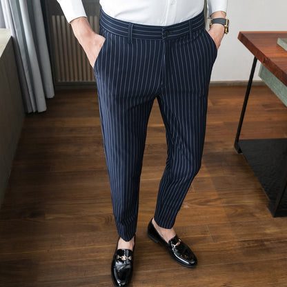 Pantaloni eleganti a righe blu scuro, uomo in camicia bianca, scarpe nere lucide, moda maschile, abbigliamento formale, stile moderno.