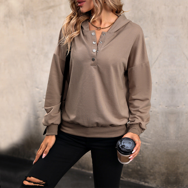 Donna con felpa marrone con bottoni, pantaloni neri strappati, tiene un caffè da asporto. Moda casual autunnale, stile urbano.