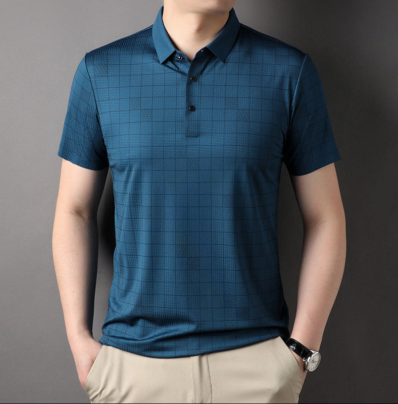 Uomo con polo blu a quadri, maniche corte, abbinata a pantaloni beige. Moda casual maschile, abbigliamento estivo elegante.