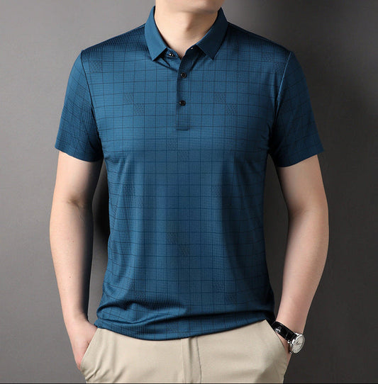Uomo con polo blu a quadri, maniche corte, abbinata a pantaloni beige. Moda casual maschile, abbigliamento estivo elegante.