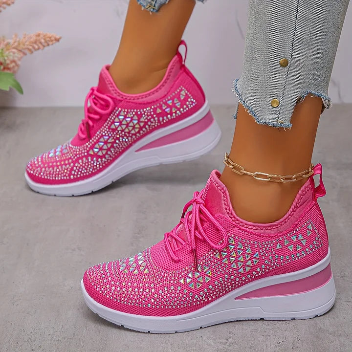 Scarpe da ginnastica rosa con motivo geometrico, suola bianca, indossate con jeans strappati. Scarpe sportive alla moda per donna.