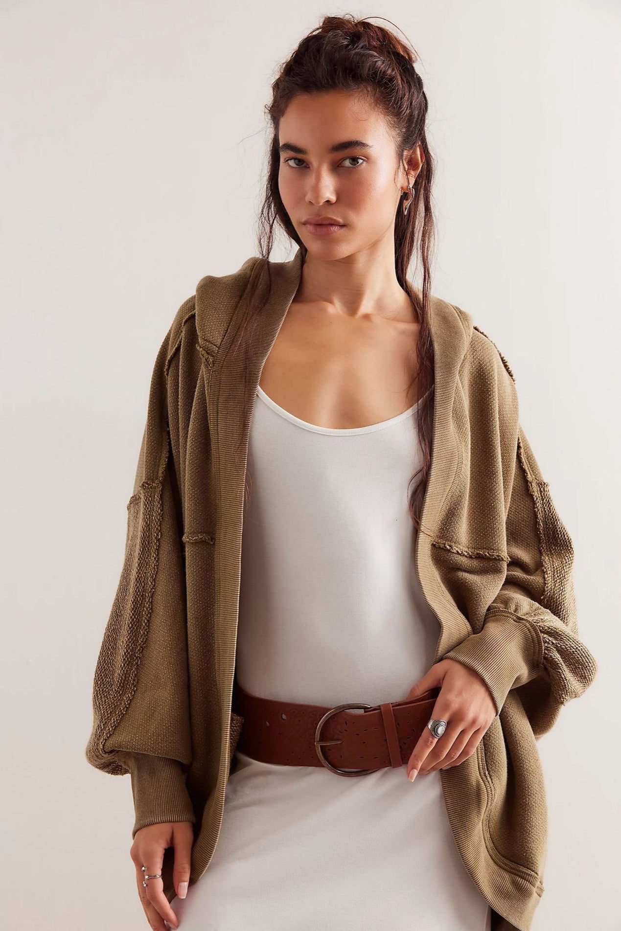 Donna con abito bianco e cardigan oversize marrone, cintura in pelle marrone. Moda autunnale, stile casual chic, abbigliamento femminile trendy.