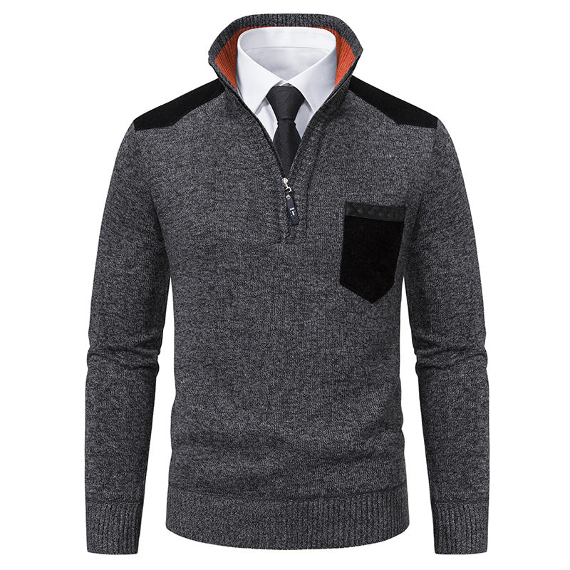 Maglione grigio scuro da uomo con zip, colletto alto, dettagli neri su spalle e taschino, indossato sopra camicia bianca e cravatta nera.