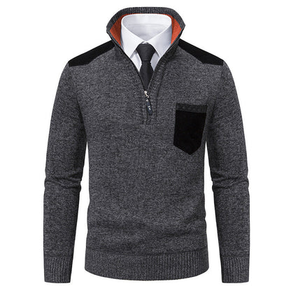 Maglione grigio scuro da uomo con zip, colletto alto, dettagli neri su spalle e taschino, indossato sopra camicia bianca e cravatta nera.