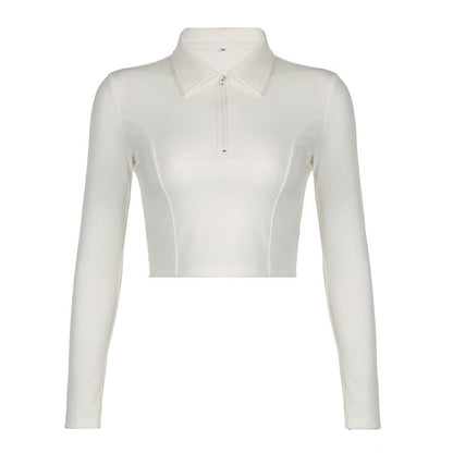 Camicia bianca a maniche lunghe da donna, stile cropped, con colletto classico e zip frontale. Moda femminile, abbigliamento casual elegante.